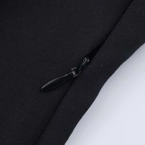 Detail of a hidden zipper closure on a black sleeveless top with neat stitching