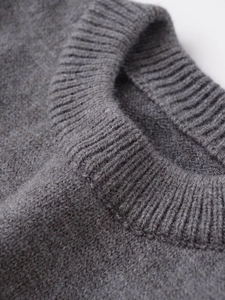 Close-up of the ribbed crew neck and fine knit texture of this grey sleeveless top