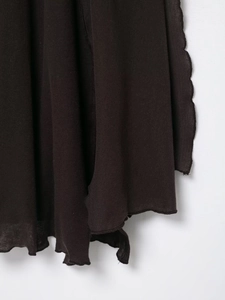 Detailed macro view of dark brown asymmetrical layered ruffle hem with wavy edges