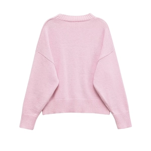 Detail of the soft pink knit sweater showing the ribbed cuffs and hem texture