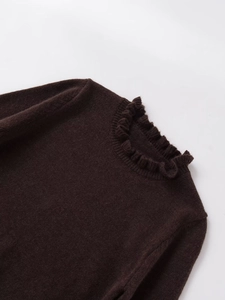 Close-up of dark brown knit sweater featuring detailed ruffle trim on the collar and shoulder
