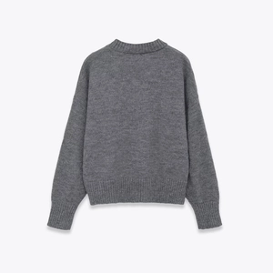 Detail view of the soft knitted fabric and ribbed hem on a grey crewneck sweater