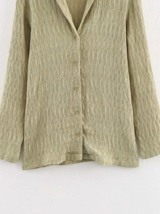 Détail de chemise de détente vert sauge texturée avec tissu plissé et patte de boutonnage