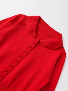 Detail of red knit cardigan featuring a Peter Pan collar and matching fabric buttons