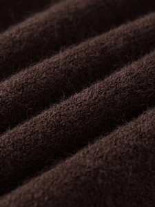 Detailed close-up of dark brown knit fabric showing rich texture and wool fibers
