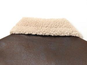 Detail shot of winter jacket featuring brown faux leather texture and cream fleece collar