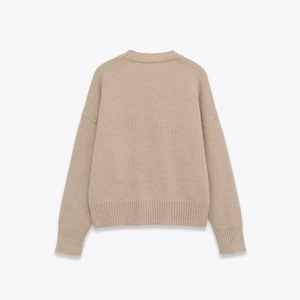 Detail view of the apricot knitted sweater back with dropped shoulders and ribbed cuffs