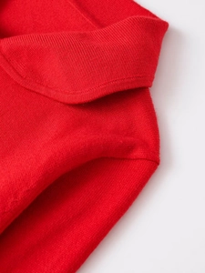 Detailed macro view of red knit cardigan shoulder seam and classic collar texture