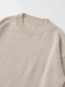 Close-up of ribbed crewneck and soft knit texture on beige minimalist sweater