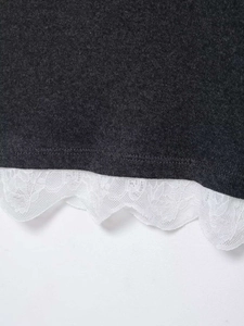 Gros plan détaillé sur le tissu en maille gris foncé avec bordure en dentelle blanche sur l'ourlet