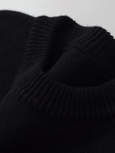 Nahaufnahme des gerippten Rundhalsausschnitts bei einem schwarzen Kaschmirpullover