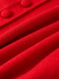 Macro shot of red knit cardigan fabric with matching fabric-covered buttons and fine texture