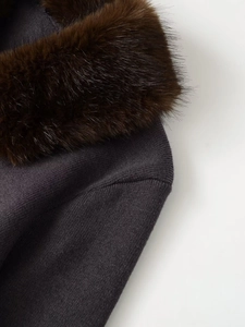 Detail of dark grey knit texture and fluffy dark brown faux fur collar on a cardigan