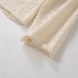 Close-up of cream chunky knit sweater showing soft texture and premium stitch detail