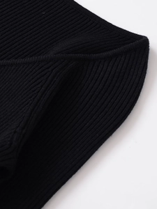 Detailed macro view of the black ribbed knit fabric and high-quality stitching texture