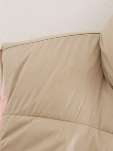 Detailopname van kaki gewatteerd vest met matte winddichte stof en fijne stiksels