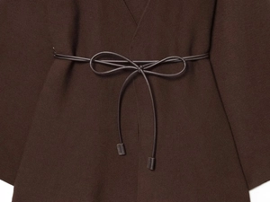 Detailed view of dark brown knitted cardigan texture with an elegant waist belt tie