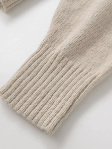 Close-up of oatmeal knit sweater showing thick ribbed cuffs and soft fiber texture