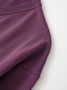 Close-up detail of soft purple knit fabric with ribbed edges and fine texture
