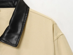 Detailed view of the black leather collar and beige canvas texture on the jacket