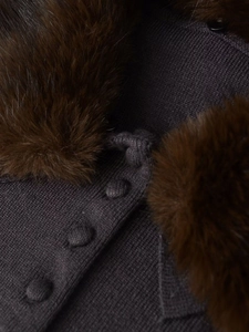 Close-up of deep gray knit cardigan featuring a plush faux fur collar and fabric-covered buttons