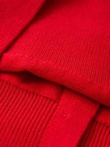 Detailed macro view of red ribbed knit fabric texture and vertical stripe stitching