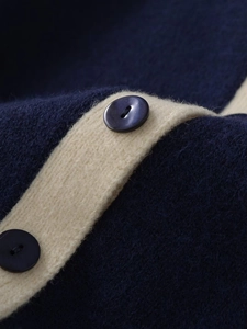 Macro shot of navy knit cardigan with contrast trim and textured wool mohair fabric