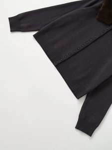 Detail of grey knit cardigan with plush faux fur collar and textured ribbed cuffs