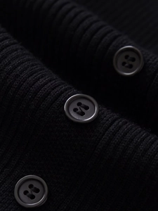 Close-up of matte black round buttons on premium ribbed knit slim midi dress fabric
