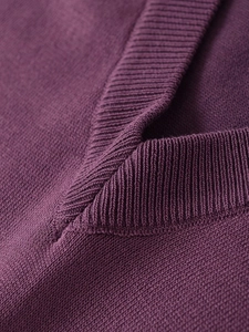 Close-up of a deep purple V-neck sweater showing premium ribbed knit collar and fine texture