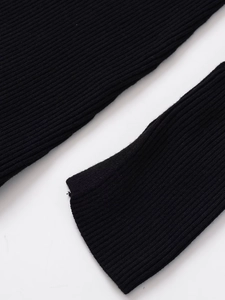 Detailed macro shot of the black ribbed knit fabric texture and sleeve cuff detail