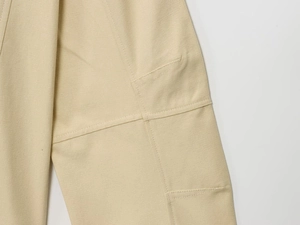 Detailed close-up showing high-density beige fabric stitching and durable cargo pocket design