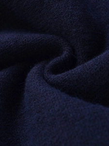 Macro detail of high-quality navy knit fabric texture showing soft wool fiber softness