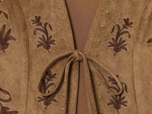 Detailed close-up of brown suede vest featuring floral embroidery and tie-up neckline