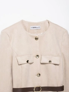 Dettaglio del blazer in camoscio albicocca con bottoni dorati e cintura in pelle