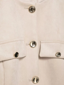 Dettaglio giacca in pelle scamosciata beige con bottoni neri decorativi bordo oro