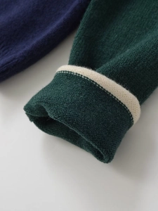 Detail of ribbed knit cuffs in forest green with ivory contrast stripe and fine texture