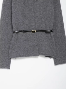 Détail du cardigan gris en maille avec fine ceinture noire et boucle dorée ovale