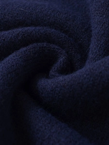 Detailed macro view showing the soft texture and thick knit of the navy blue sweater fabric
