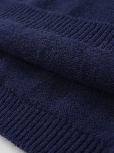Detailed macro view of navy blue ribbed knit fabric showing soft wool texture and quality