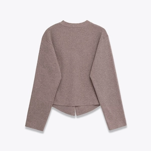 Detail of soft knit cardigan featuring a round neck and unique split hem design