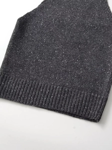 Detailed close-up of dark grey marl knit fabric and wide ribbed hem of sleeveless top