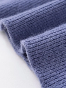 Macro shot of light blue cable knit texture showing detailed soft ribbed fabric structure