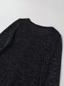 Détail d'un haut en maille noire métallique avec col rond et fibres scintillantes fines