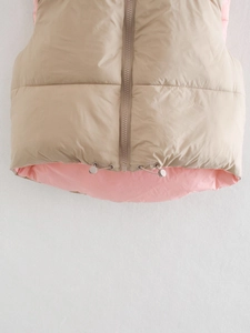 Detail van kaki puffer vest met roze voering, rits en verstelbaar koord in de zoom