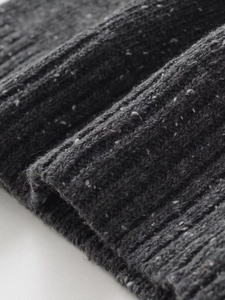 Detail of dark grey rib-knit fabric with salt and pepper texture and soft folds