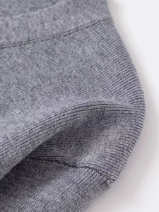 Close-up of premium grey knit cardigan fabric showing fine texture and rolling edge