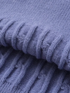 Detailed close-up of dark violet cable knit texture on a chunky rib-knit sweater