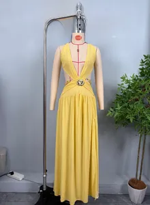 Détail de la découpe à la taille avec boucle fleur dorée sur robe longue moutarde