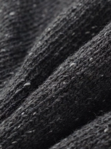 Macro detail of dark grey ribbed knit fabric with subtle white speckled fiber texture